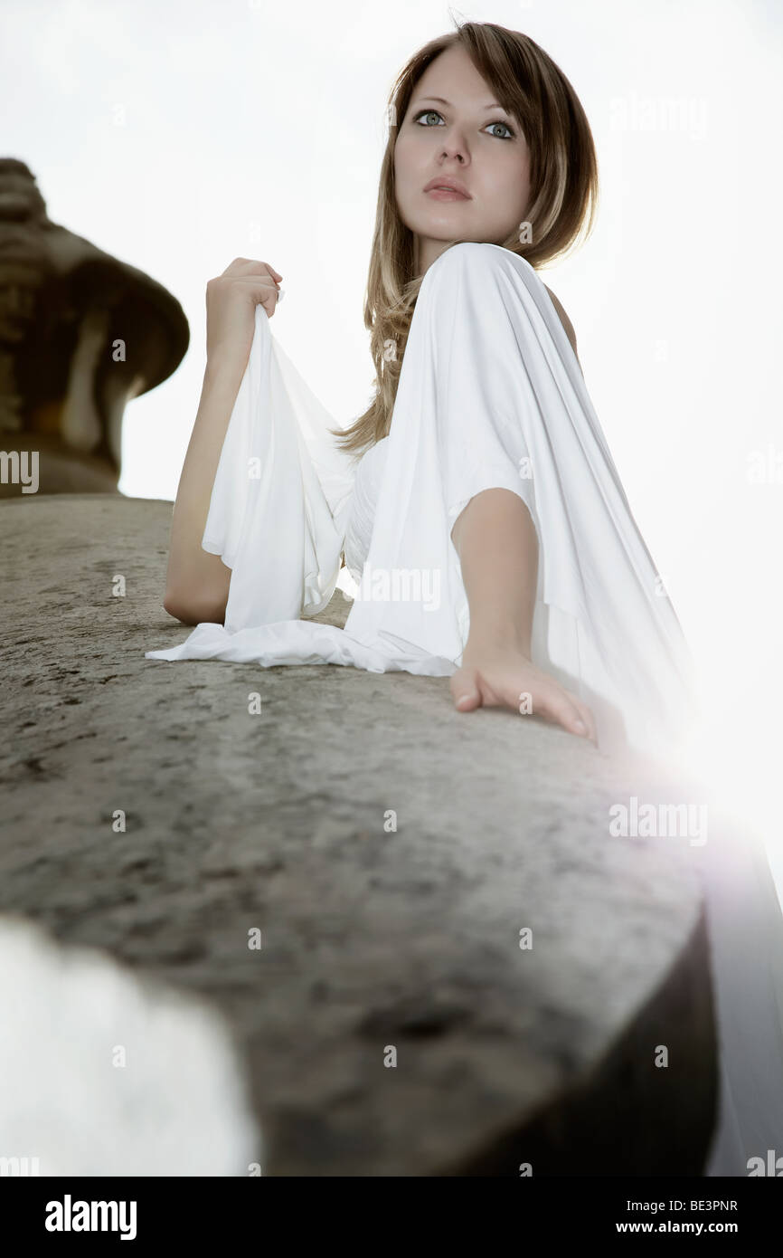 Photo de Mode d'une jeune femme blonde en robe blanche avec long train s'appuyant sur le garde-fou du pont Alexander, Pa Banque D'Images