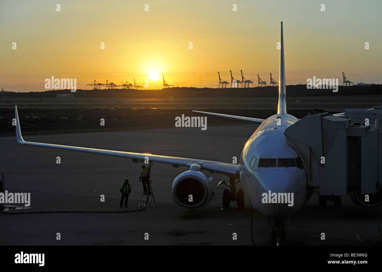 Qantas Airlines Boeing 717 ravitaillement en vol au lever du soleil, l'Aéroport International de Brisbane, les grues à l'arrière, port, Brisbane, Queensl Banque D'Images