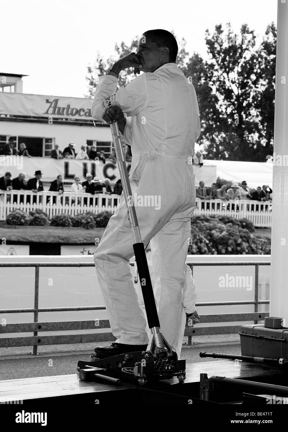 Un mécanicien attend dans la fosse et regarde les courses automobiles à la Goodwood Revival Banque D'Images