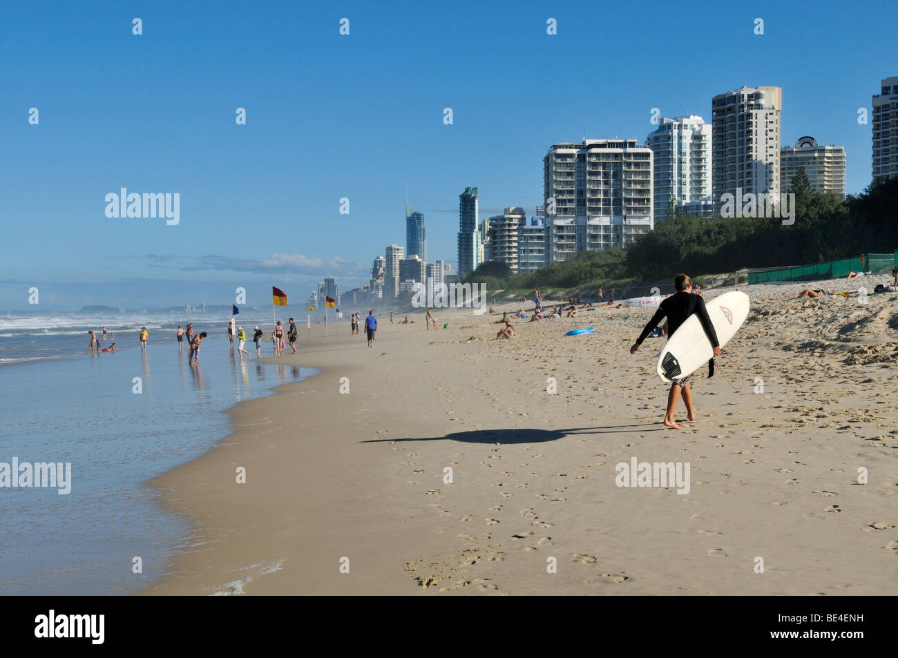 Homme avec une planche de surf sur la plage de Surfers Paradise, Gold Coast, Queensland, Australie Banque D'Images