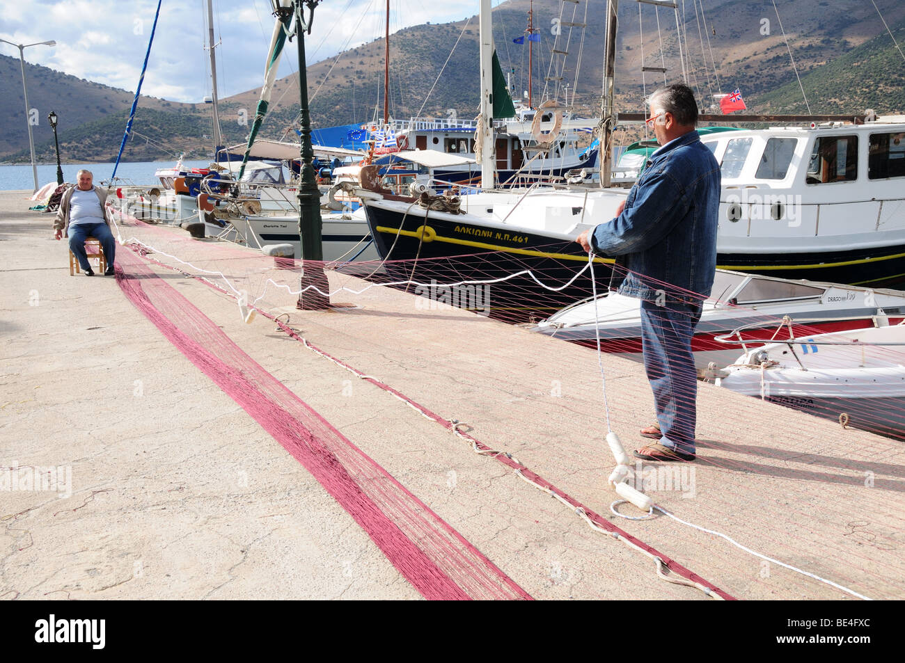 Deux hommes grecs rendant les filets de pêche du village de pêche d'Eubée Grèce Panagia Banque D'Images