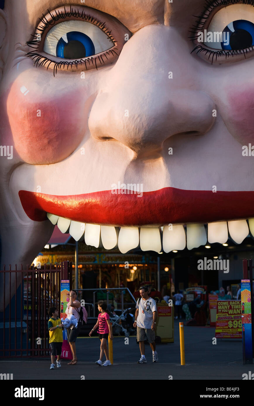 La famille à l'entrée au visage souriant de Luna Park. Côte-Nord, Sydney, New South Wales, Australia Banque D'Images