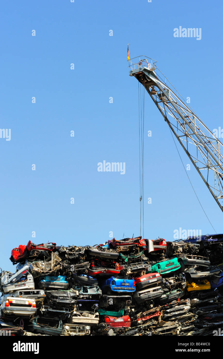 Voitures anciennes et une grue de chargement sur un junkyard Banque D'Images