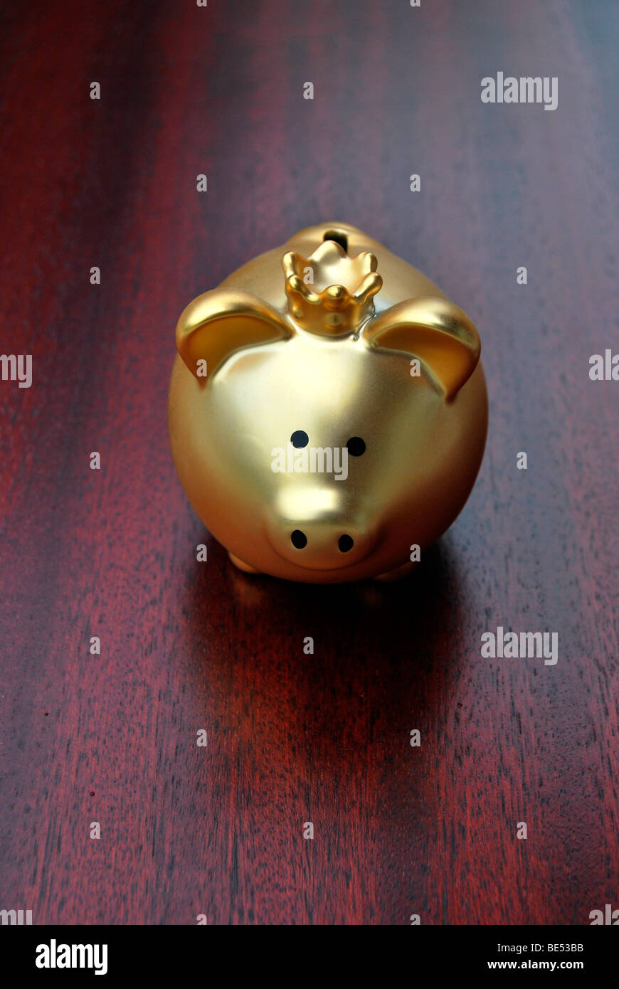 Tirelire avec une couronne, d'or, sur un bureau en acajou Banque D'Images
