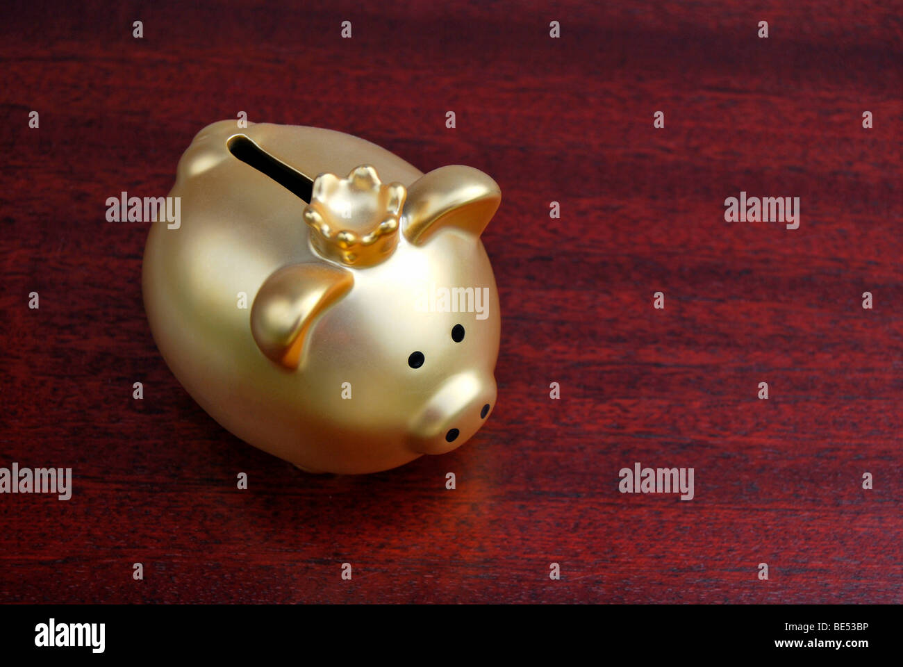 Tirelire avec une couronne, d'or, sur un bureau en acajou Banque D'Images