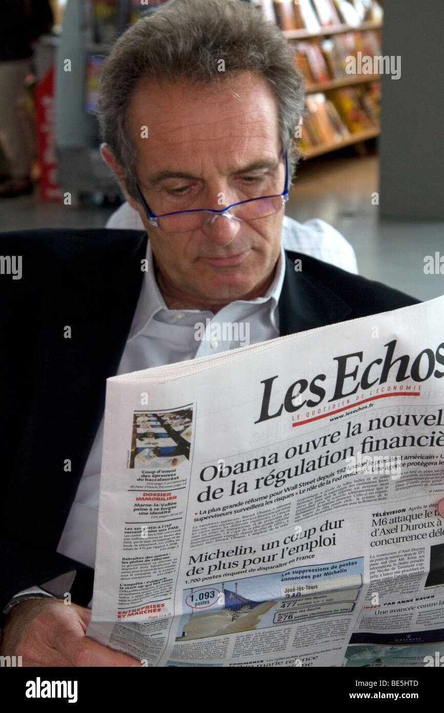 L'homme la lecture d'un journal de langue française à Nice, France. Banque D'Images