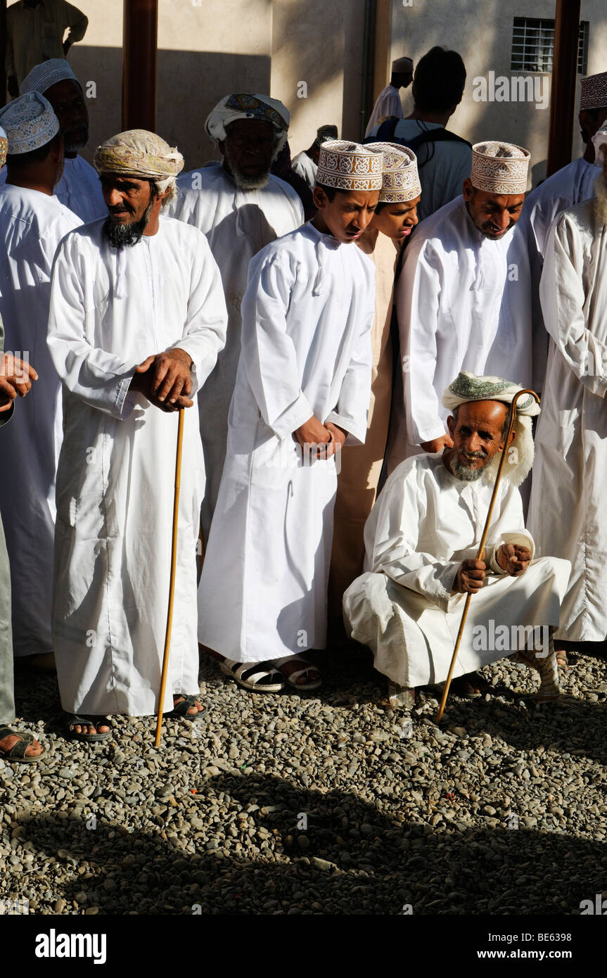 Les hommes en costume traditionnel omanais, le bétail ou les animaux marché à Nizwa, Hajar al Gharbi, Montagnes, région Dakhliyah Al Sultanat Banque D'Images