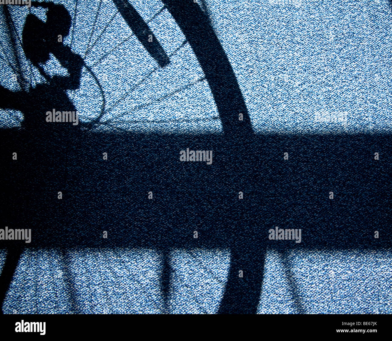 Roue de vélo ombre sur tapis bleu Banque D'Images