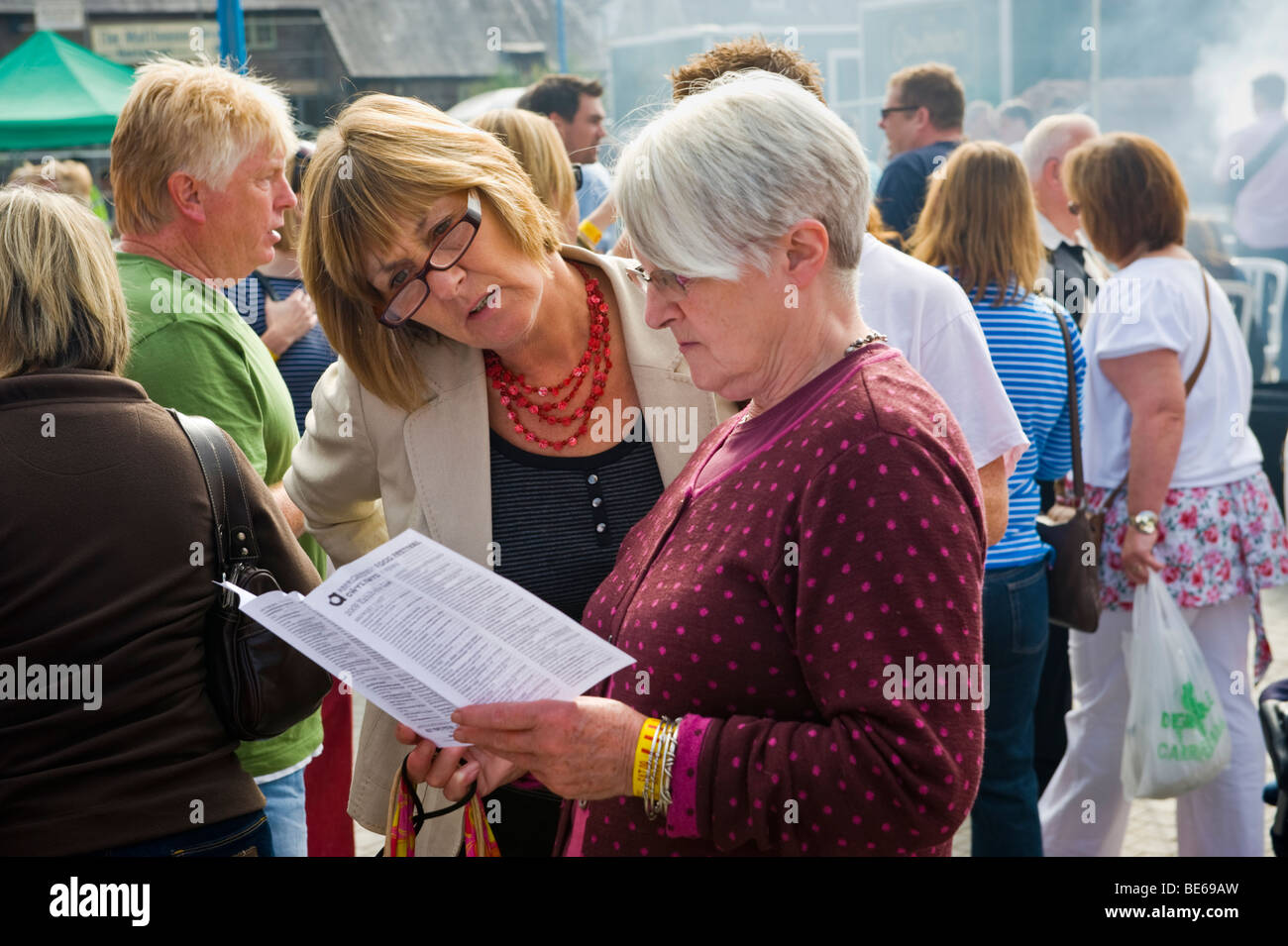 Les gens qui lisent des dépliants à Abergavenny Food Festival Monmouthshire South Wales UK Banque D'Images