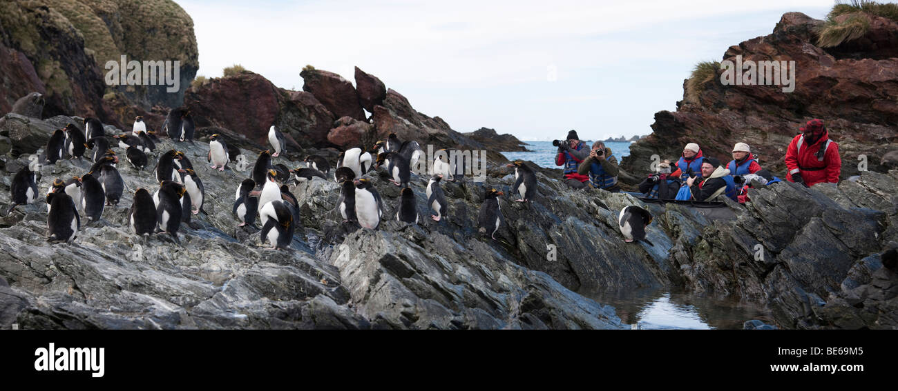 Les passagers de croisière panoramique, éco-touristes d'explorer la côte rocheuse sur zodiac excursion à photographie rock-bac des pingouins dans l'Antarctique Banque D'Images