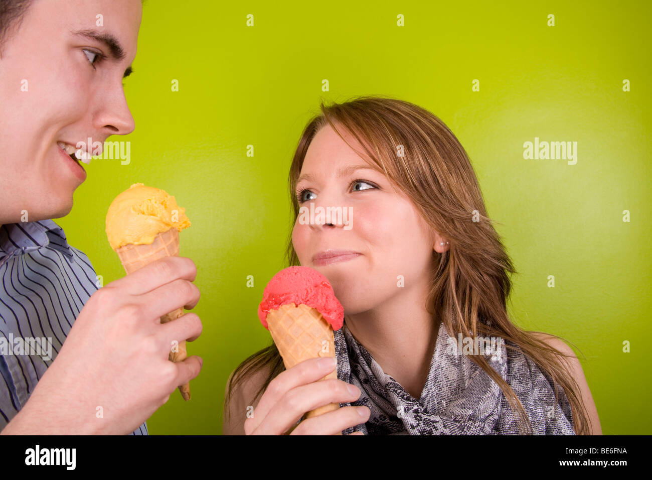 Un jeune homme et femme partageant des cornets de crème glacée. Banque D'Images
