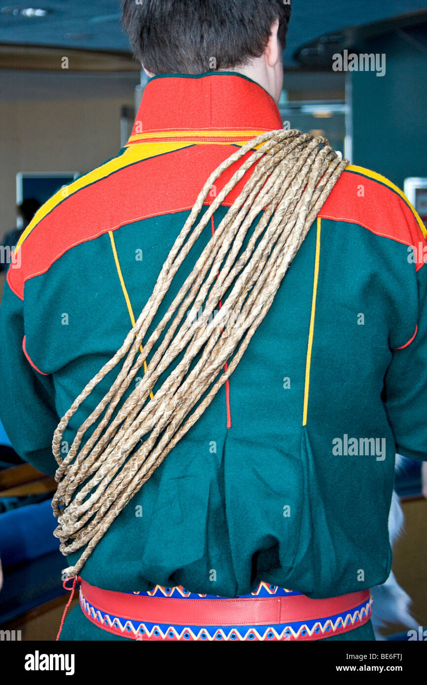 Jeune homme en costume traditionnel sami parle de la vie de son peuple et a fait montre d'acier tressé des tendons du renne. Banque D'Images