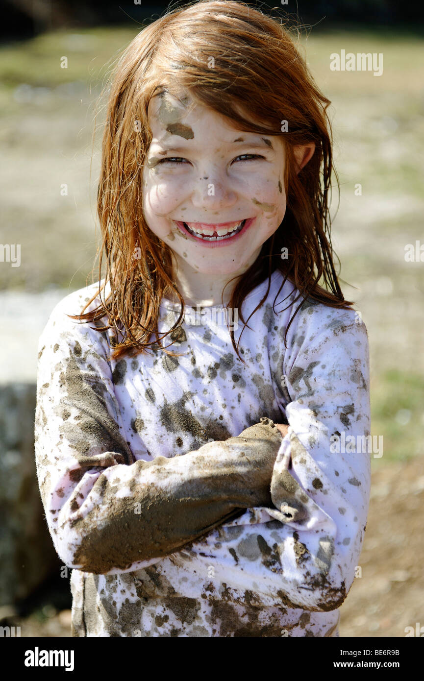 Enfant totalement couvert de boue, sale, sauvage, fille atypique Banque D'Images