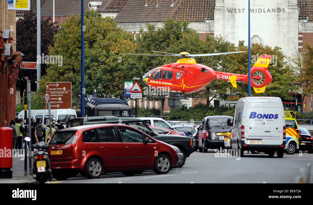 Les Midlands de l'ambulance aérienne par hélicoptère en vol stationnaire À BASSE ALTITUDE AU-DESSUS DU CENTRE-VILLE DE BIRMINGHAM, Royaume-Uni Banque D'Images