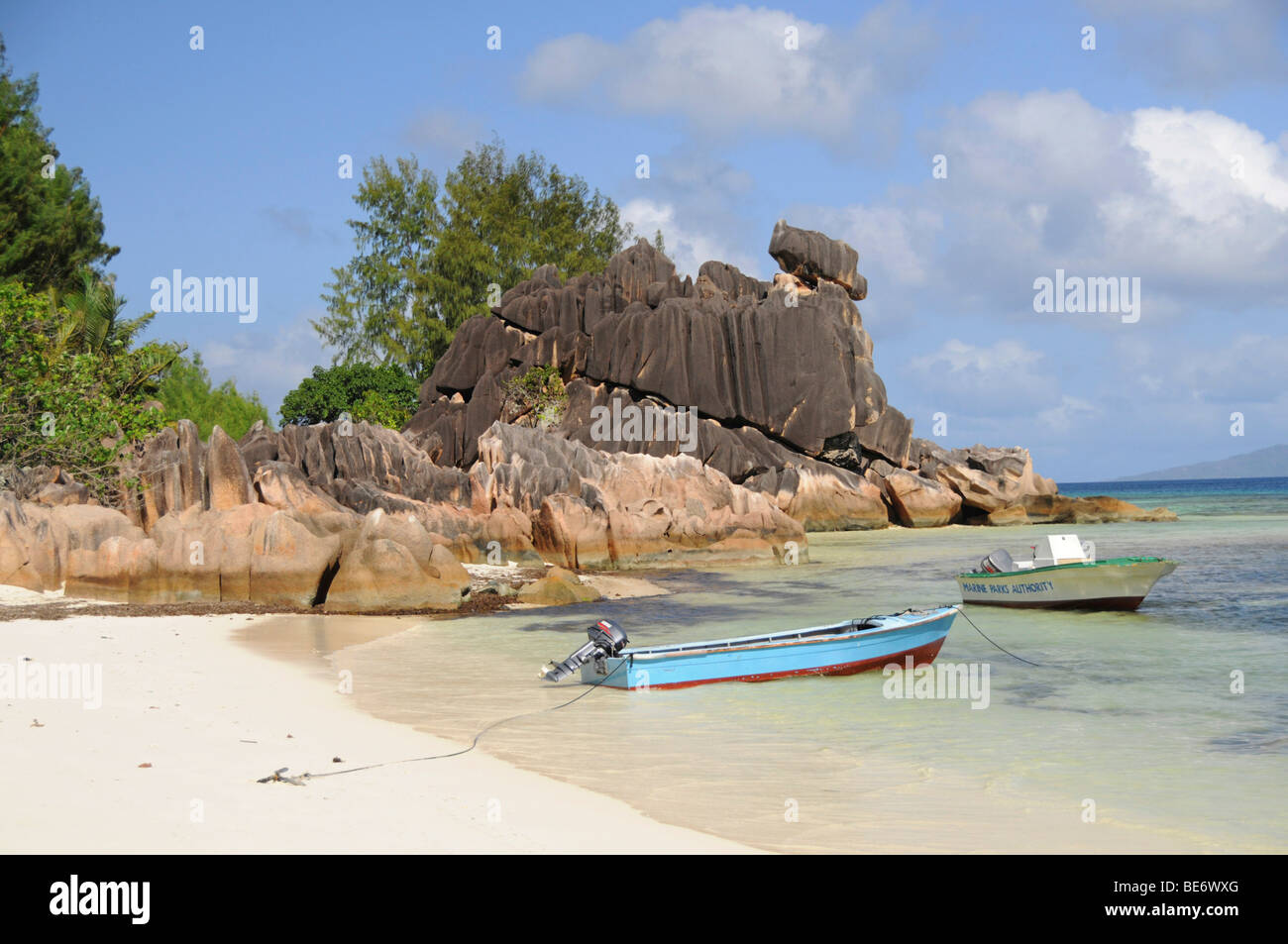 Bateaux en face de rochers de granit, l'île Curieuse, Seychelles, Afrique, Océan Indien Banque D'Images