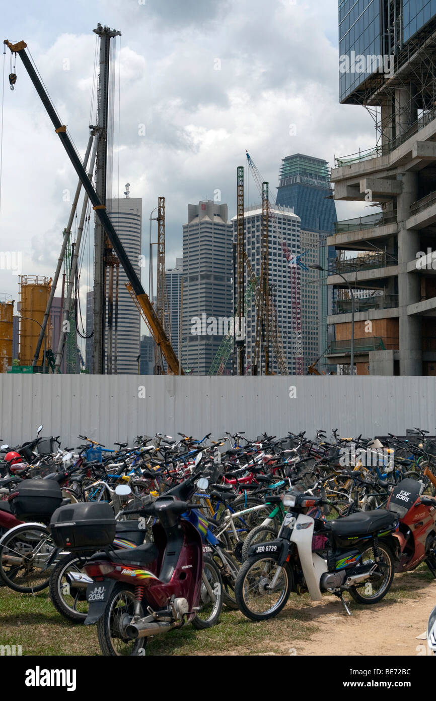 Des vélos et scooters en face d'un site de construction, de construction à Singapour, en Asie Banque D'Images