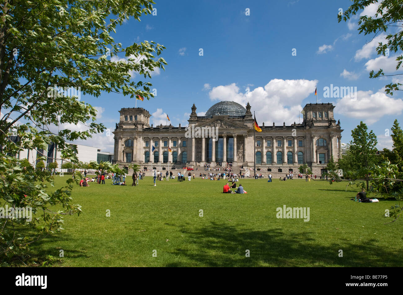 Les gens profiter d'une journée d'été sur la pelouse en face du parlement de l'Allemagne, le Reichstag à Berlin. Banque D'Images