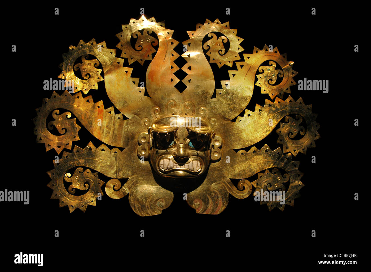 Masque ancien péruvien fabriqué à partir d'or et saphir isolé sur un fond noir Banque D'Images