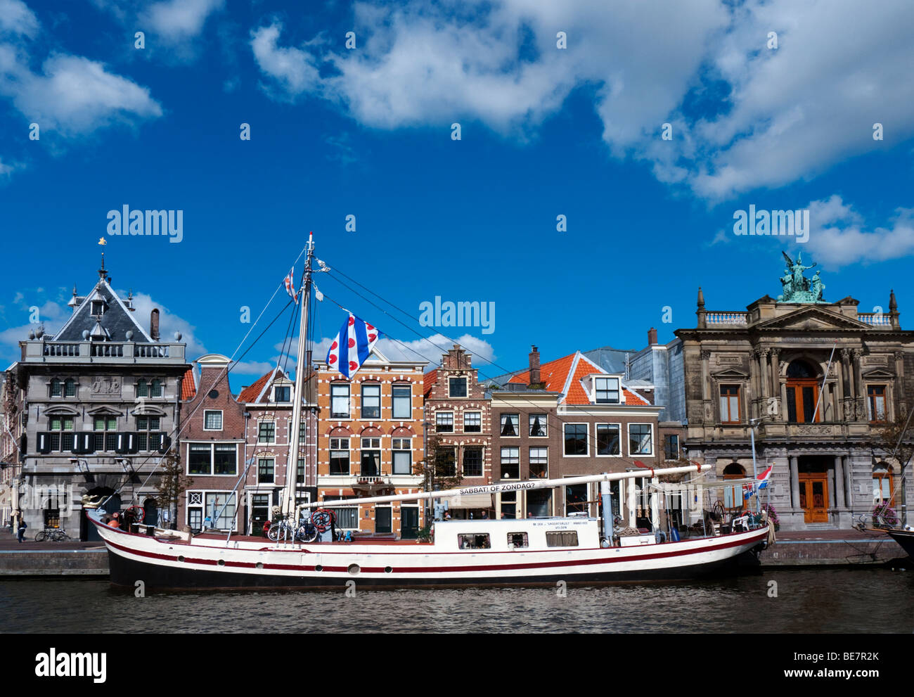 Bateau amarré sur la rivière Spaarne et maisons historiques dans Haarlem Pays-Bas Banque D'Images