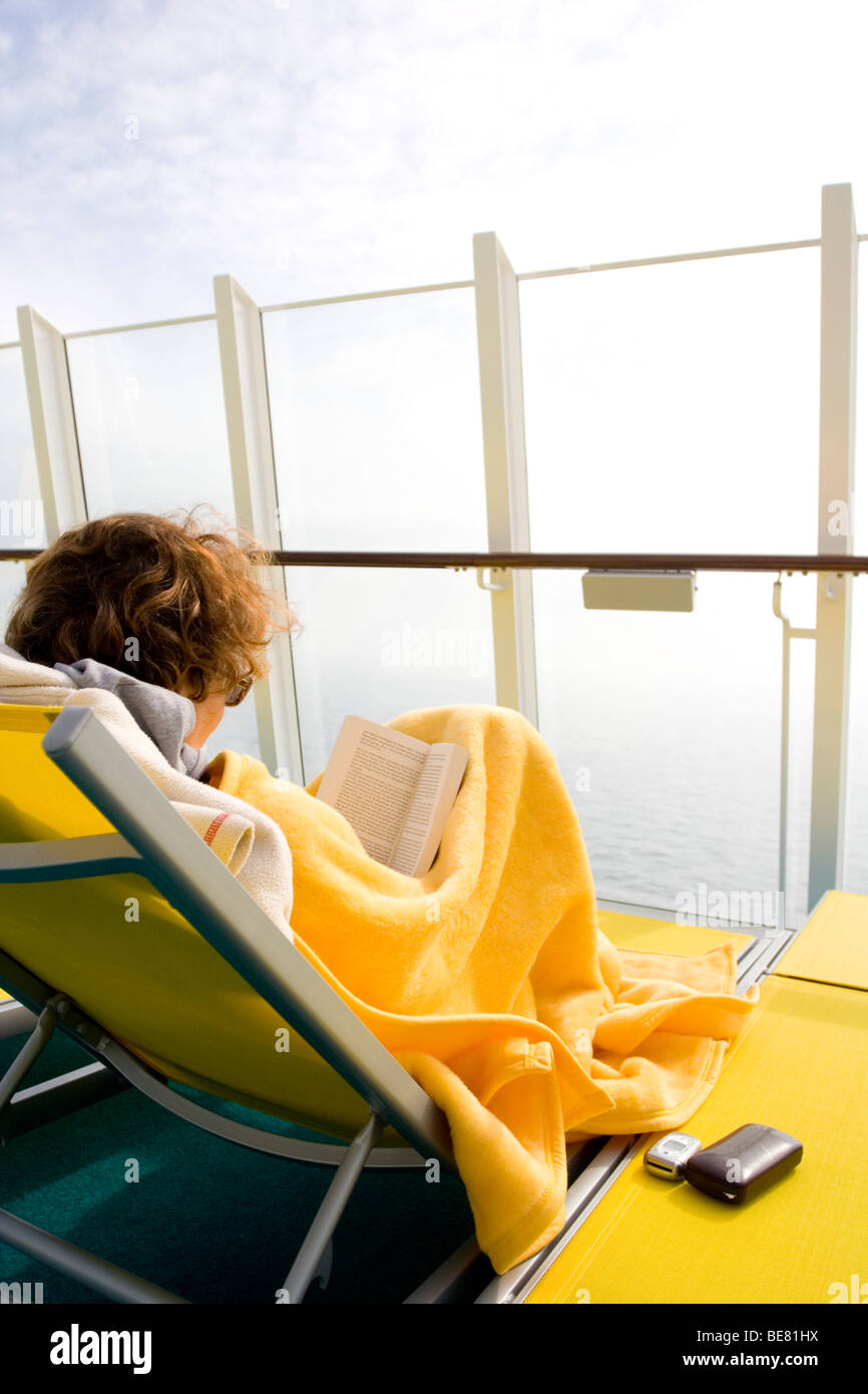 Une femme lisant sur le pont du navire de croisière AidaDiva Banque D'Images