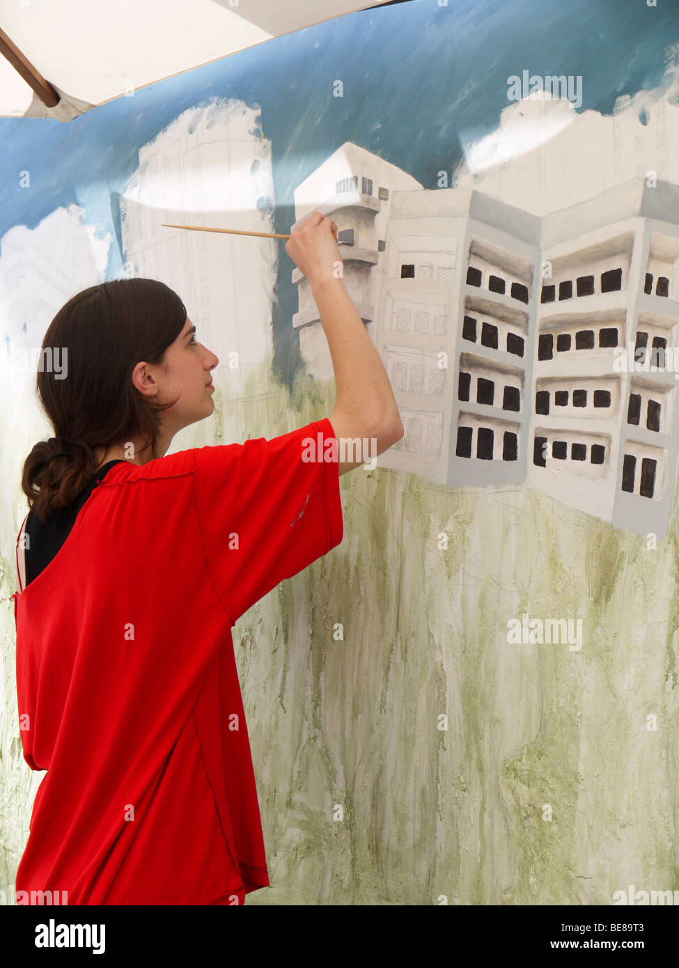 Israël, Tel Aviv, une femme artiste peint un paysage urbain d'immeubles de style Bauhaus Banque D'Images