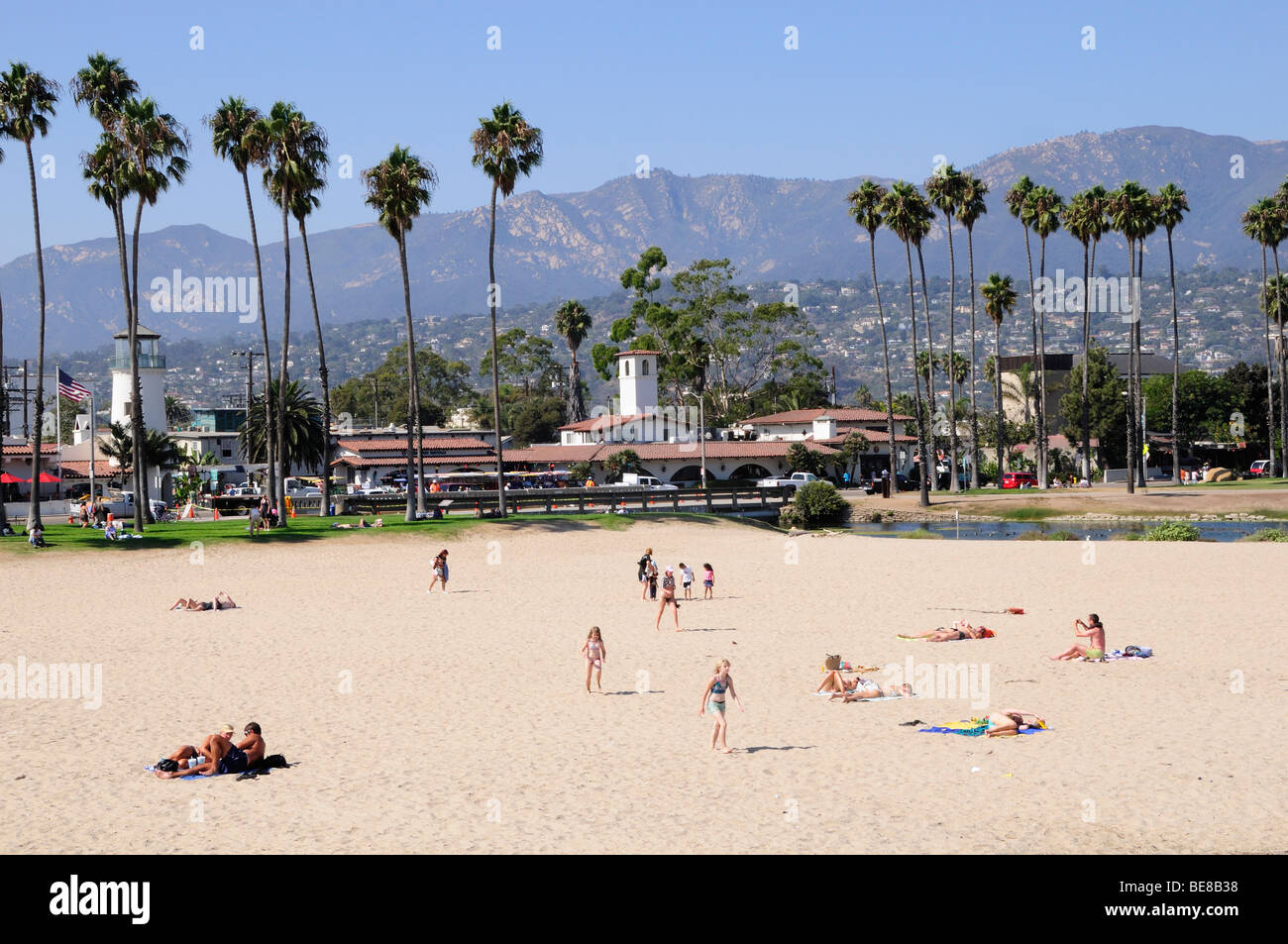 USA, Californie, Santa Barbara, les gens sur la plage est de sable fin  bordée de palmiers et une vue sur les montagnes au-delà Photo Stock - Alamy