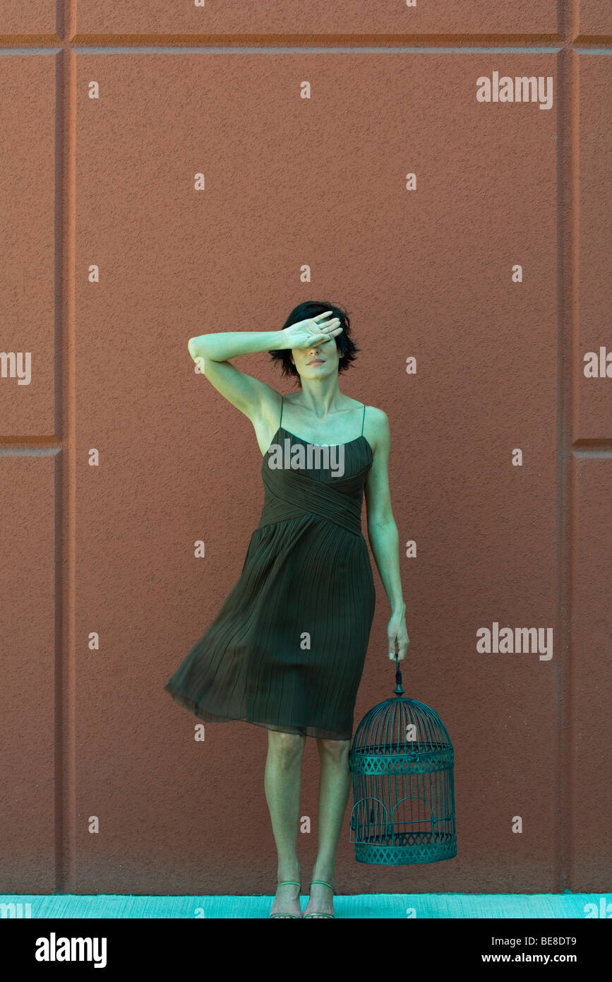 Woman holding empty birdcage, dos de la main qui a eu lieu au front Banque D'Images