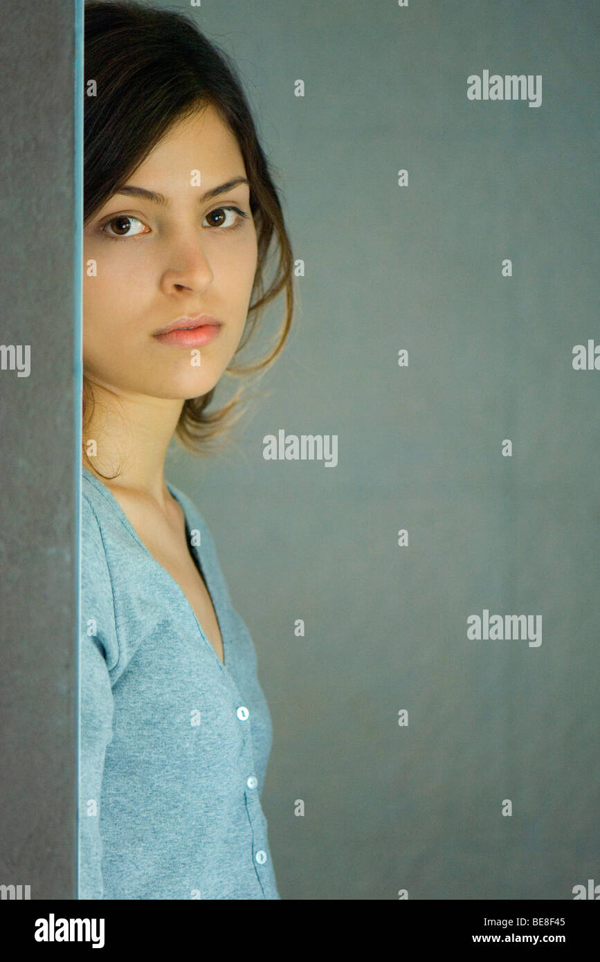 Young woman leaning against wall, portrait Banque D'Images