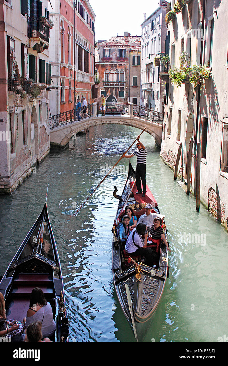 Gondoliers amènent les touristes à Venise, sur une promenade en bateau à travers les canaux merveilleux de la ville.L'Italie Banque D'Images