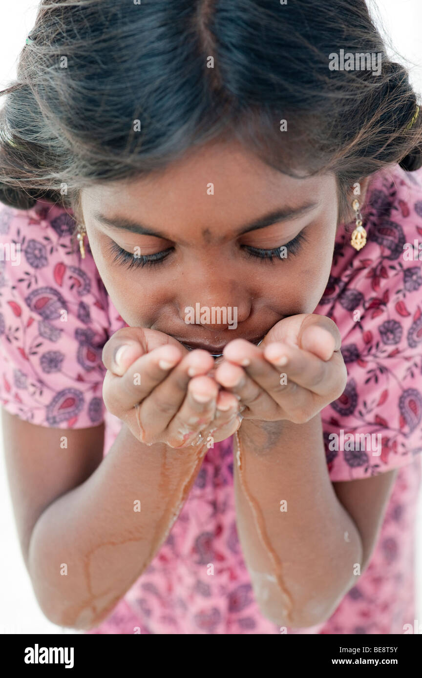 Indian girl with creux des mains de l'eau potable. L'Inde Banque D'Images