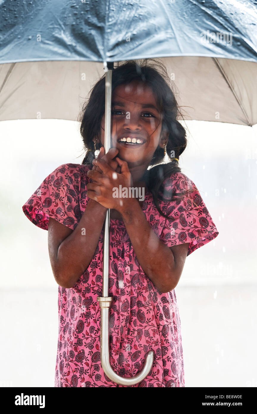 Jeune indienne sous un grand parapluie pendant la mousson Banque D'Images