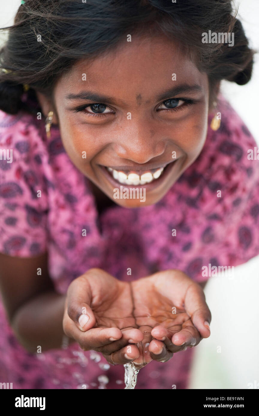 Indian girl with creux des mains de l'eau potable Banque D'Images