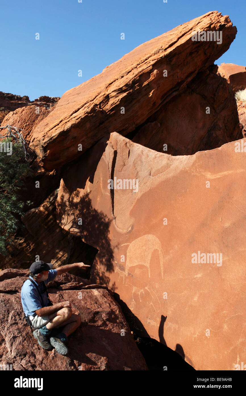 À la recherche de gravures Bushman antique (pétroglyphes) à Twyfelfontain dans le Damaraland en Namibie Banque D'Images
