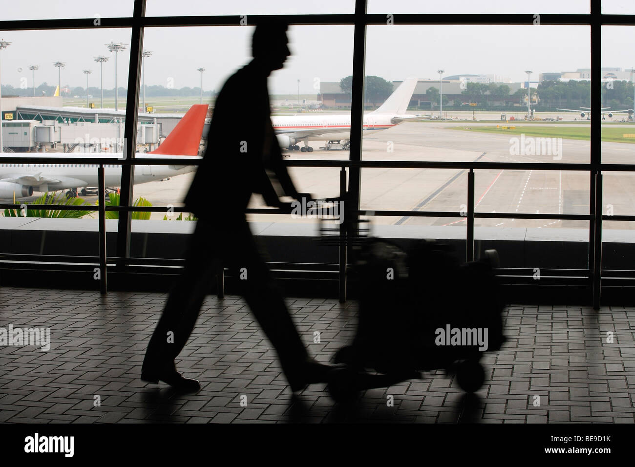 Man pushing trolley à l'aéroport Banque D'Images