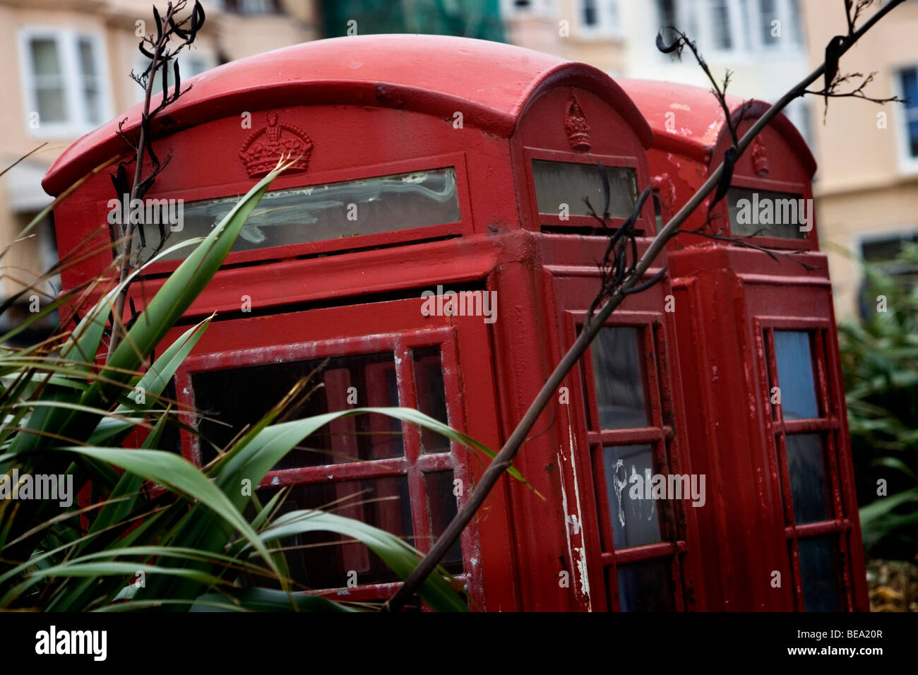 Old fashioned British Telecom téléphone rouge fort en mauvais état avec grafitti et envahis par les environs, Brighton, Royaume-Uni. Banque D'Images