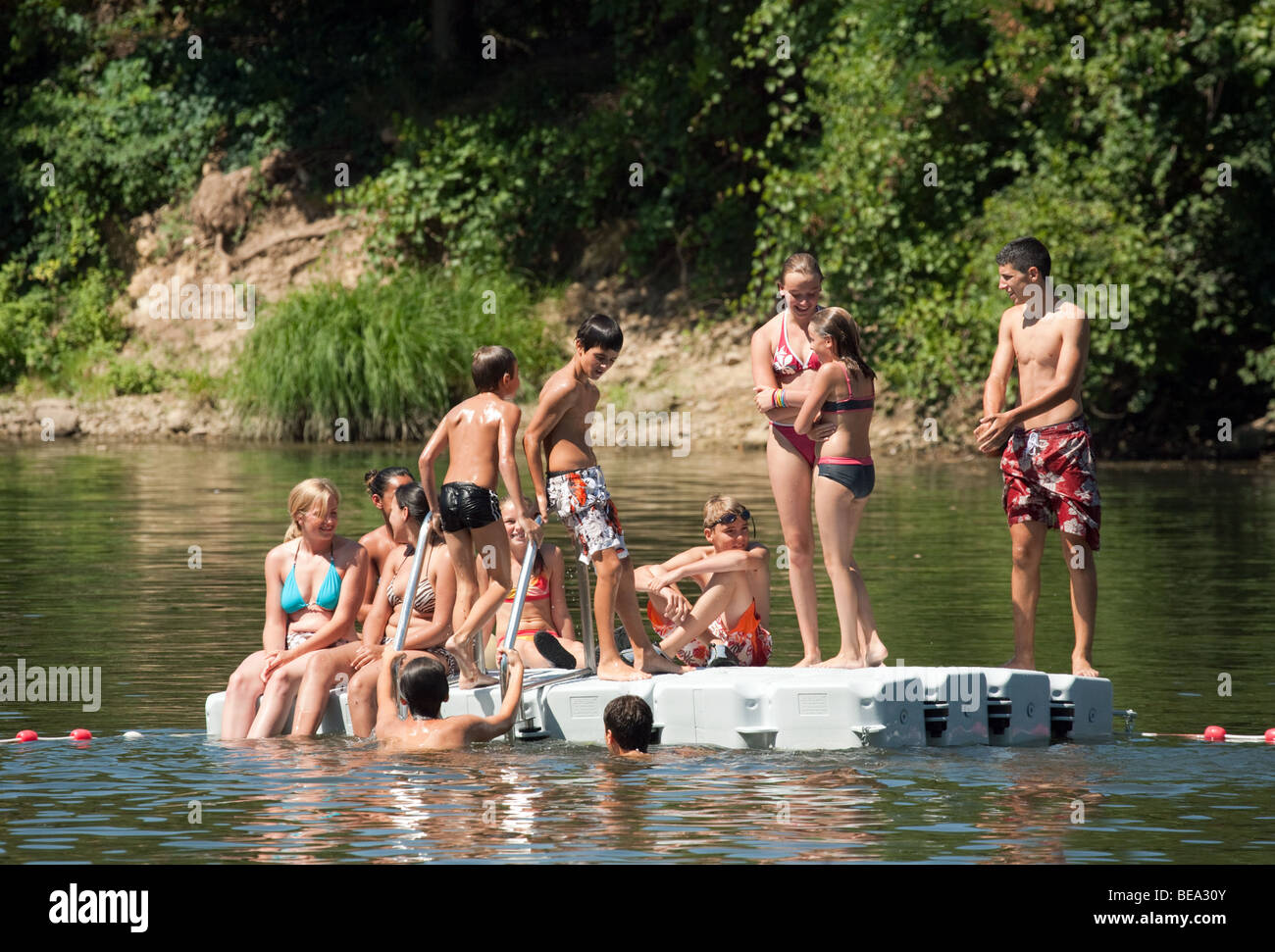 Adolescents jouant sur un ponton dans la rivière Lot, Castelmoron, Aquitaine, France Banque D'Images