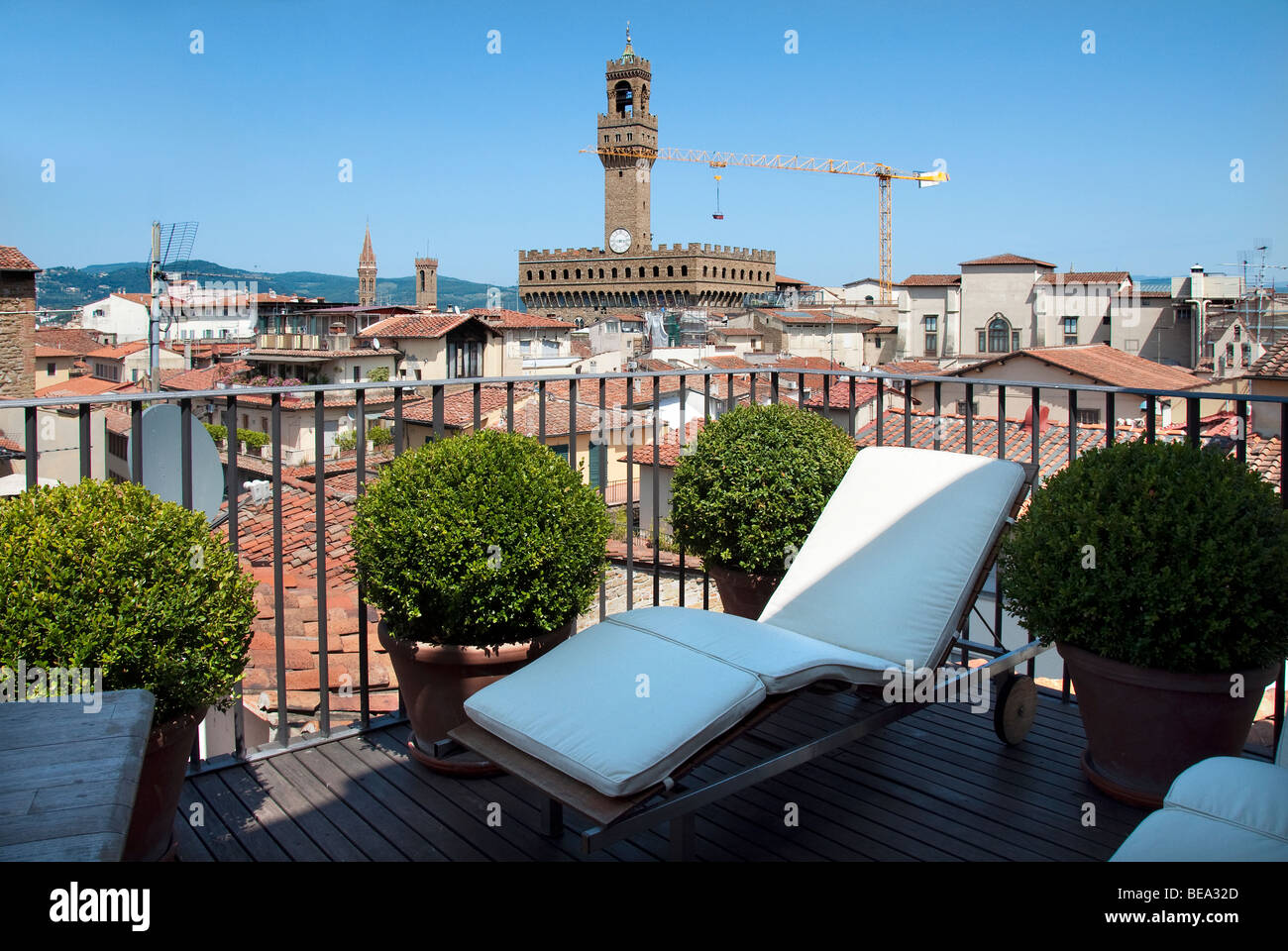 Soleil chaise longue sur le balcon de la suite penthouse de l'hôtel Continentale avec une vue sur le Palazzo Vecchio à Florence Banque D'Images