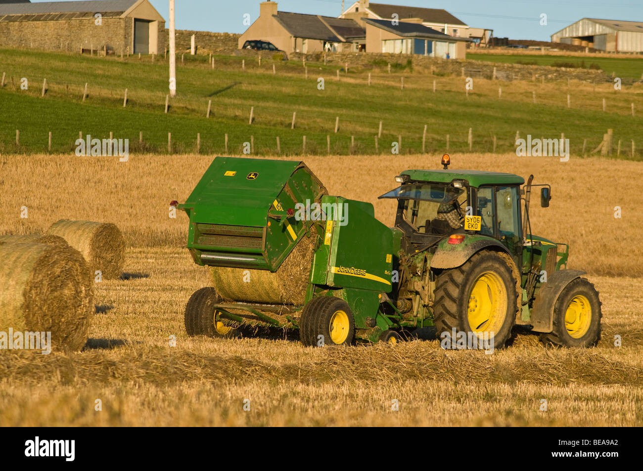 dh John Deere tracteur presse RÉCOLTE Royaume-Uni balles de récolte de foin machine agriculture dans orkney écosse machines tracteurs à rouleaux Banque D'Images