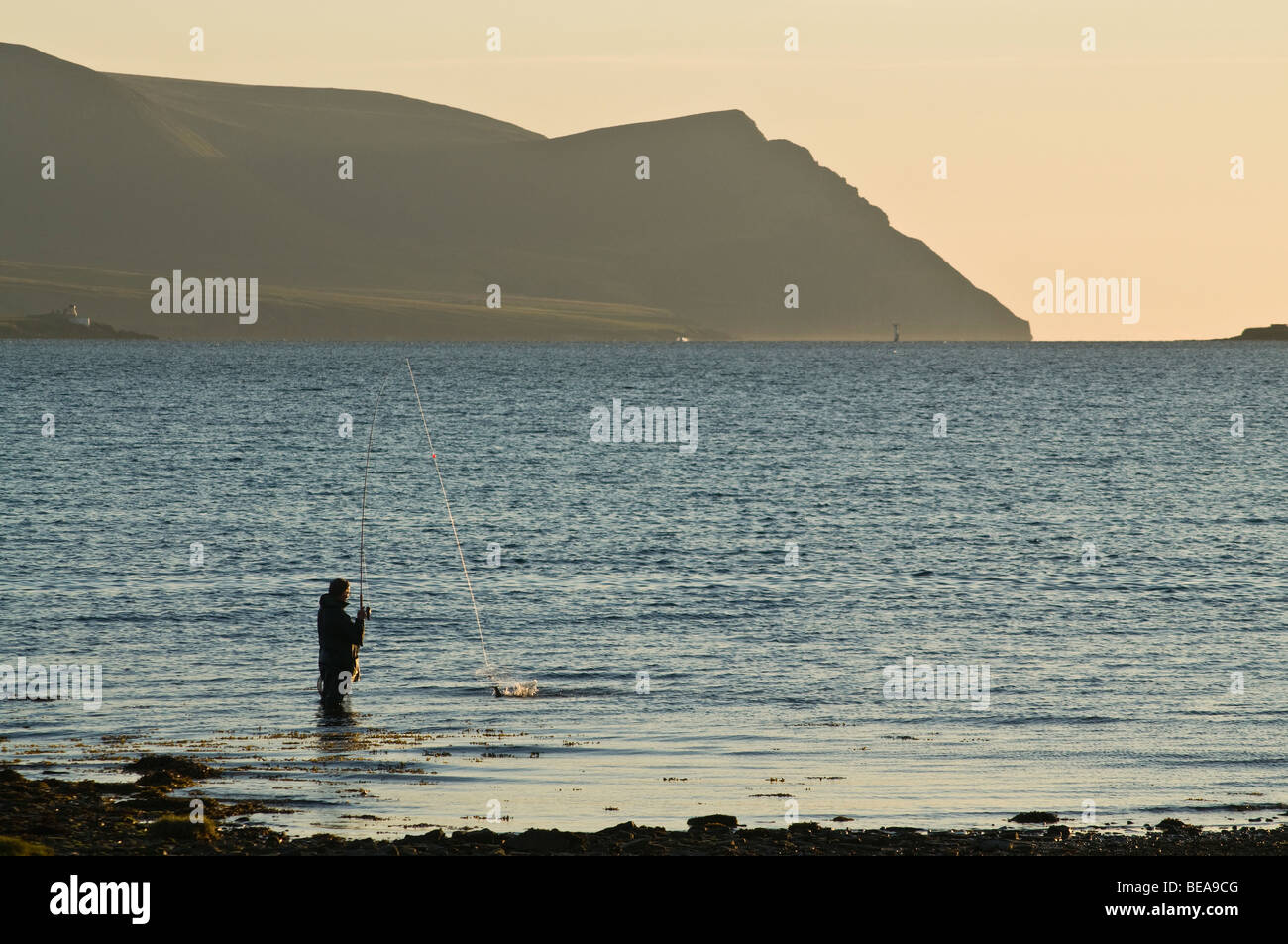 Pêche à la ligne pêcheur dh ORKNEY Scapa Flow Ecosse gué off shore fisherman casting soirée Hoy hills Banque D'Images