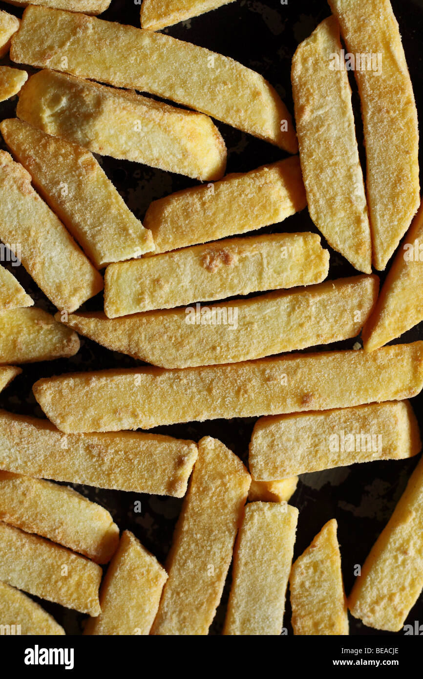 Plus de chips de pommes de terre pré cuits congelés en copeaux sur une plaque de cuisson pour la cuisson Banque D'Images
