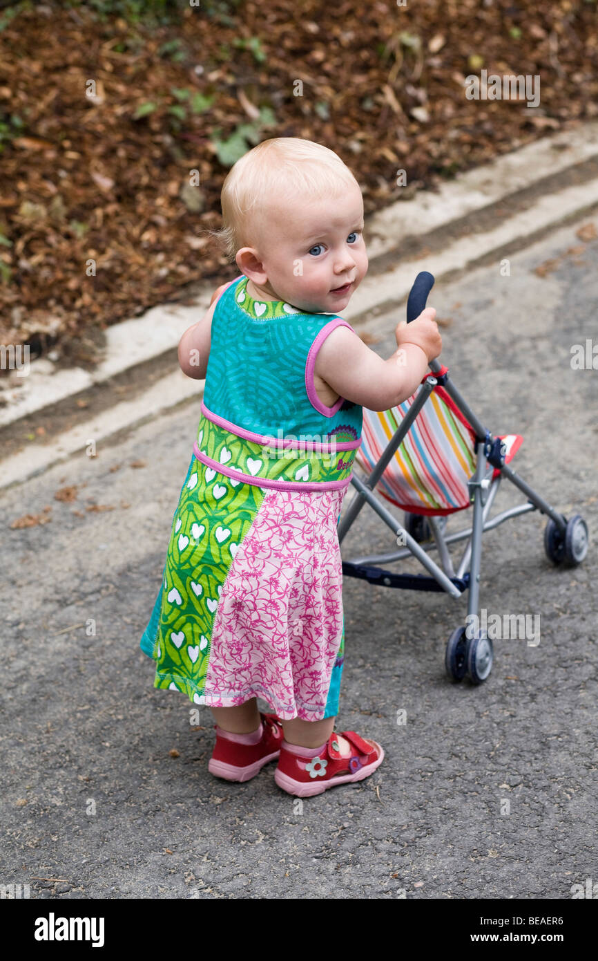Un bambin avec une poussette de bébé Banque D'Images