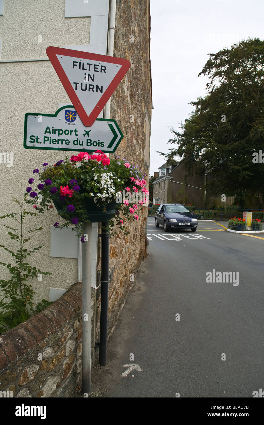 dh ST MARTIN GUERNESEY Guernesey filtre à tour de rôle signe avec des fleurs et voiture dans boîte filtre intersection Banque D'Images
