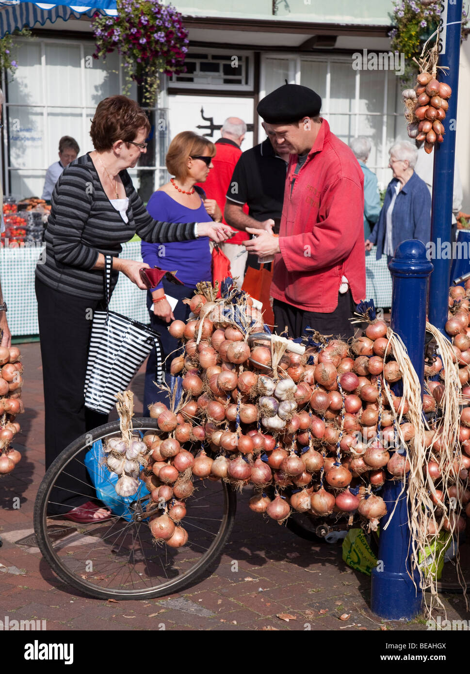 Vendeur d'Oignons avec les oignons et l'ail à la vente à Abergavenny food festival Wales UK Banque D'Images