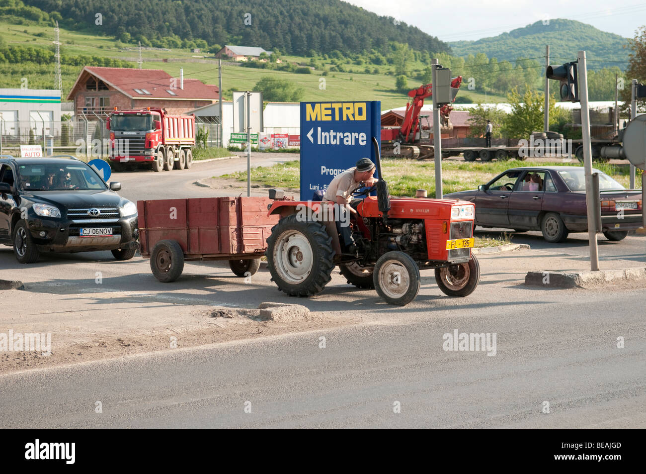 Agriculteur sur le tracteur rouge avec remorque à Cluj Napoca Roumanie Europe de l'Est Banque D'Images