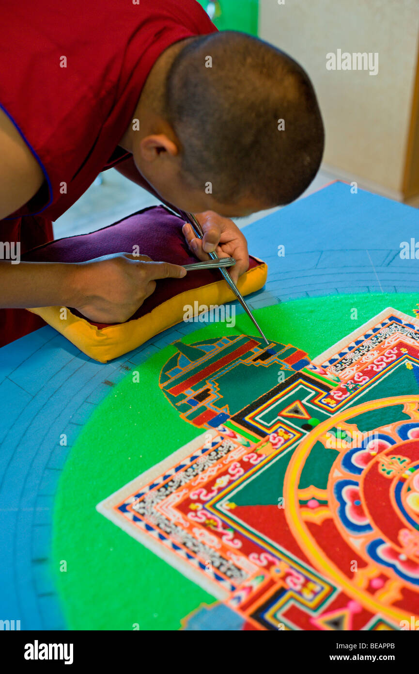 Moine tibétain Yeshi Choedup travaille avec soin sur un mandala de sable coloré dans la région de Ruidoso, Nouveau Mexique. Banque D'Images