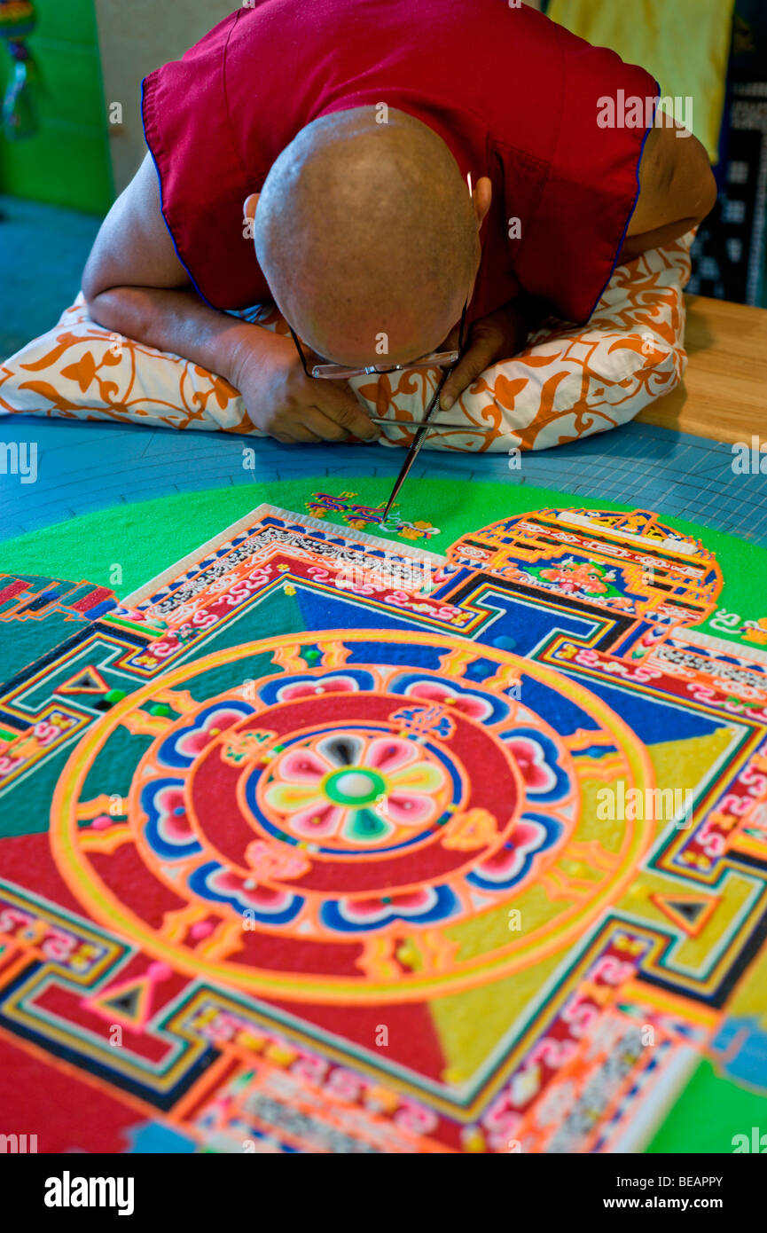 Moine tibétain Tsering VenoDhondup travaille avec soin sur un mandala de sable coloré dans la région de Ruidoso, Nouveau Mexique. Banque D'Images