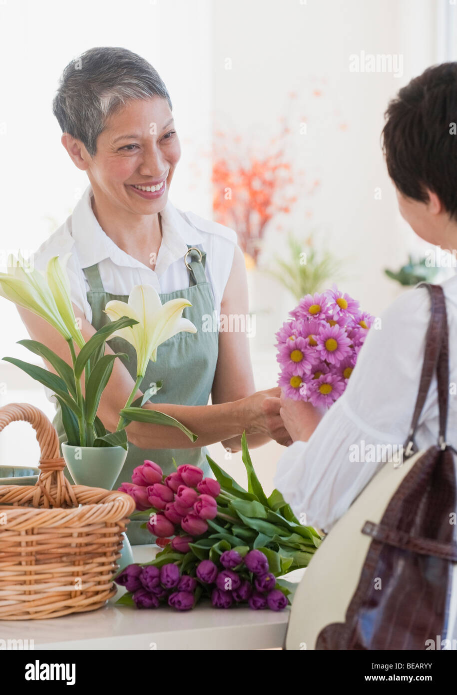 Fleuriste chinois donnant des fleurs au client Banque D'Images