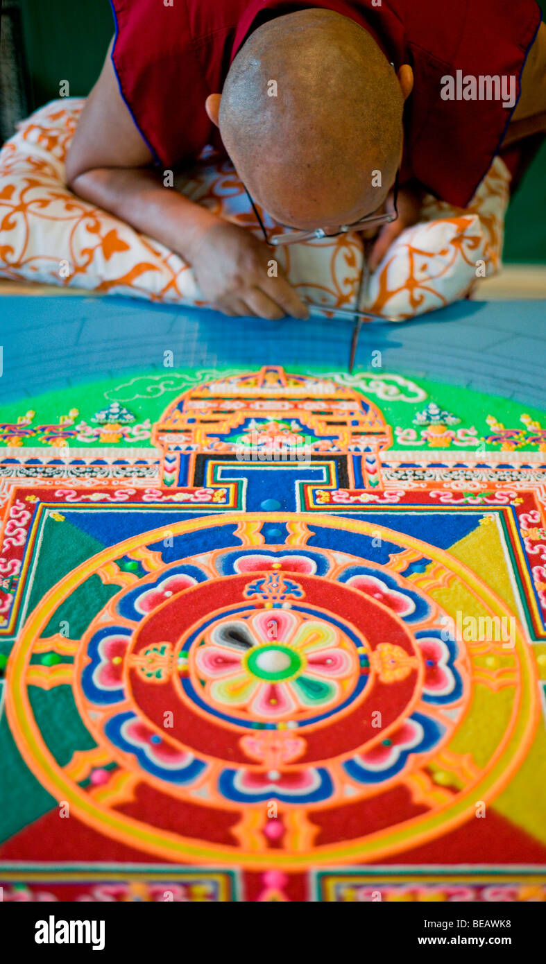 Moine tibétain Tsering VenoDhondup travaille avec soin sur un mandala de sable coloré dans la région de Ruidoso, Nouveau Mexique. Banque D'Images