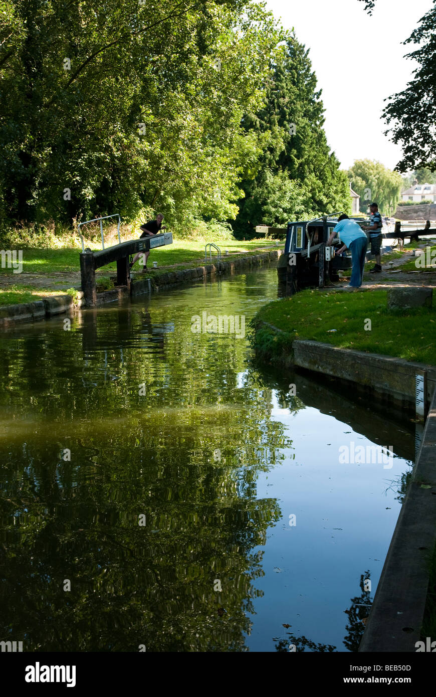 L'homme et la femme pour verrouiller la porte d'ouverture à Hungerford Bateau étroit sur le canal Kennet et Avon Banque D'Images