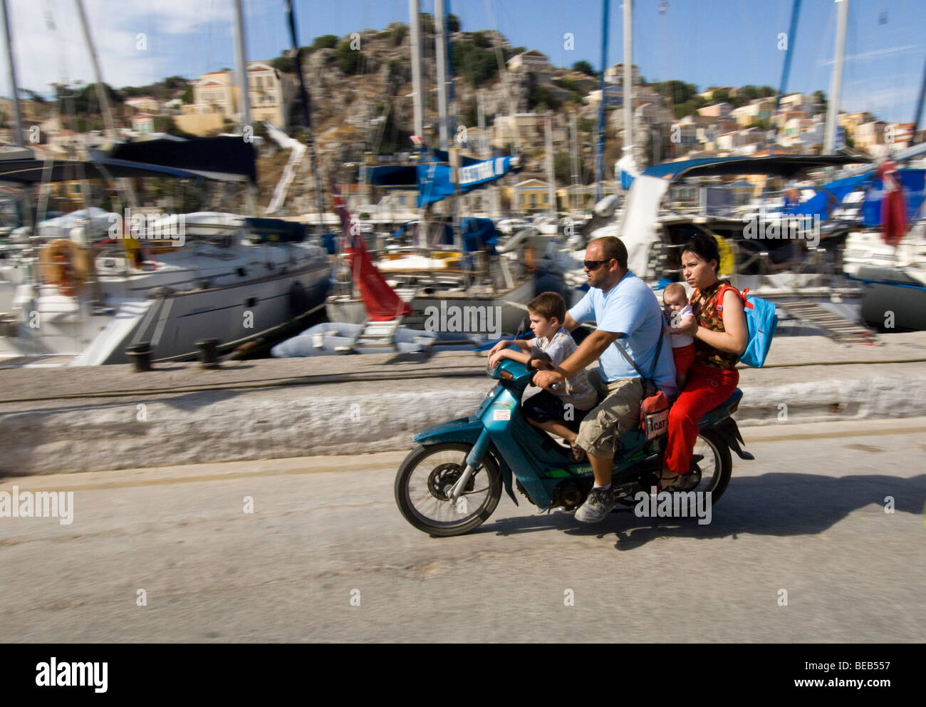 Quatre personnes sur un petit cyclomoteur. Billet d'une famille grecque sur une moto sans casque. Banque D'Images
